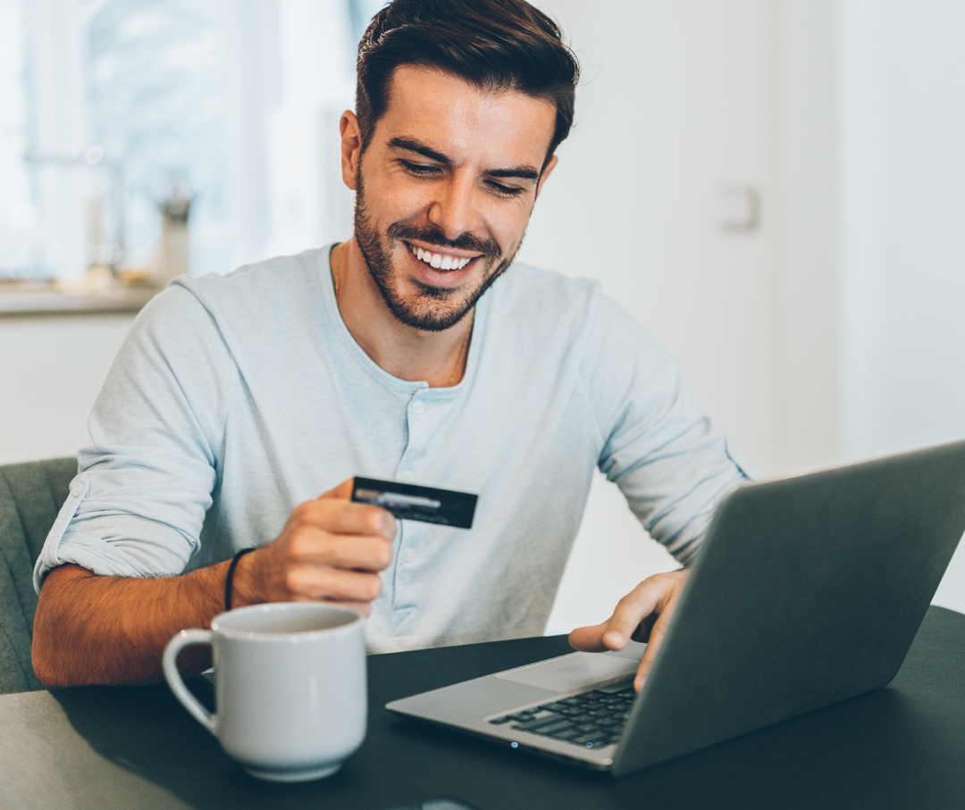 Man sitting in front of the computer with a credit card purchasing a tub.