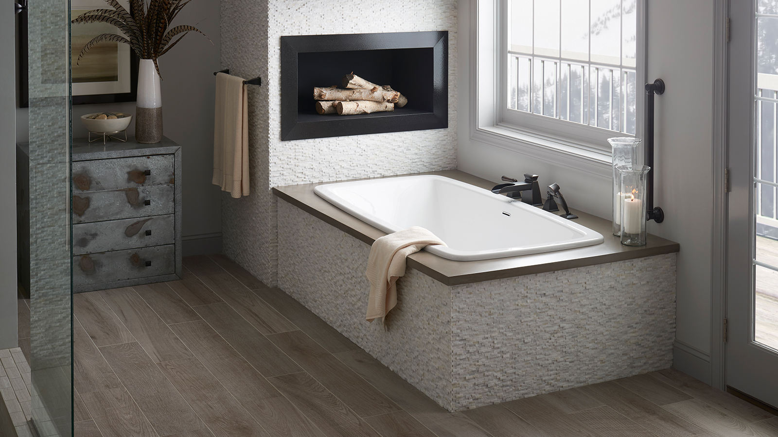 Image of a drop-in tub that has a rock tile skirt around it.