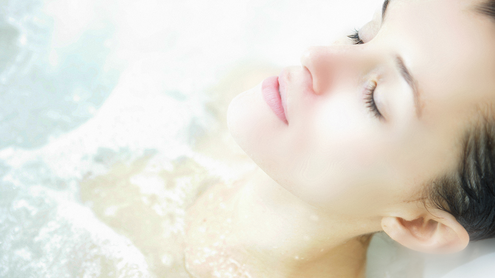 Image of a woman relaxing in a jetted deep soaking tub.