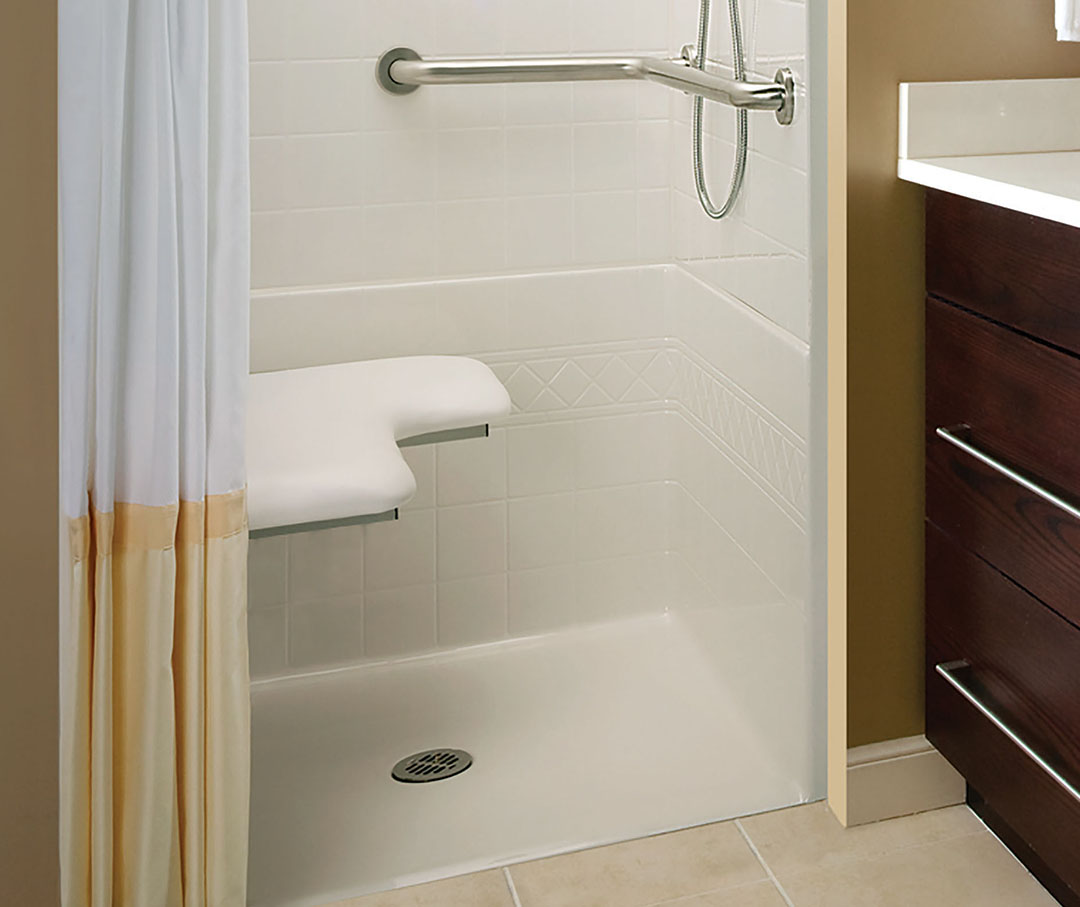 Hand railings in shower with a center drain in a smaller bathroom.