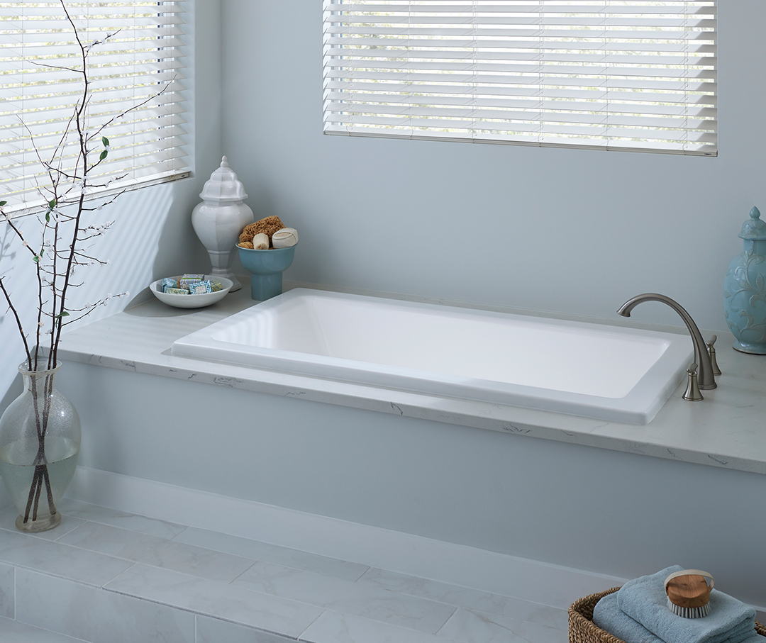 Image of a drop-in tub with marble around it.