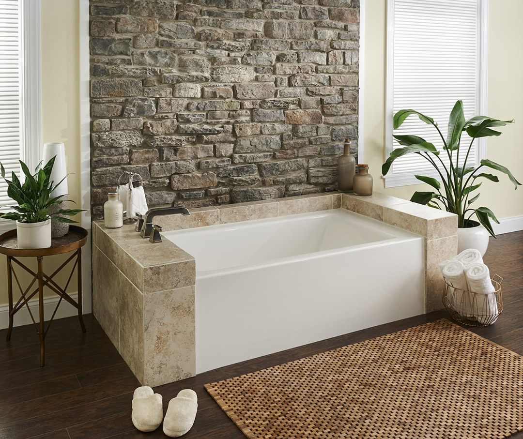 Image of a skirted tub in the center of a wood floor bathroom.